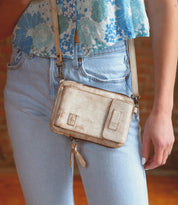 A woman wearing premium leather jeans and a Bed Stu purse, Bed Stu cell phone holder.