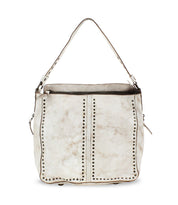 The Packet LTC by Bed Stu is a white leather shoulder tote bag with a single strap, featuring a zip closure and decorative metal studs arranged in vertical lines on the front.