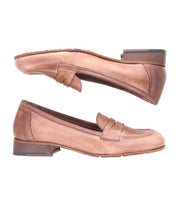 A pair of brown Italian leather loafers with low heels, side view. The classic style is evident with the top shoe sole-side up and the bottom shoe right-side up. The Bed Stu Paris showcases timeless elegance and craftsmanship.