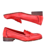 A pair of red Italian leather loafers with brown heels, shown from the side, with one shoe upright and the other upside down, showcasing the classic style of Paris by Bed Stu.