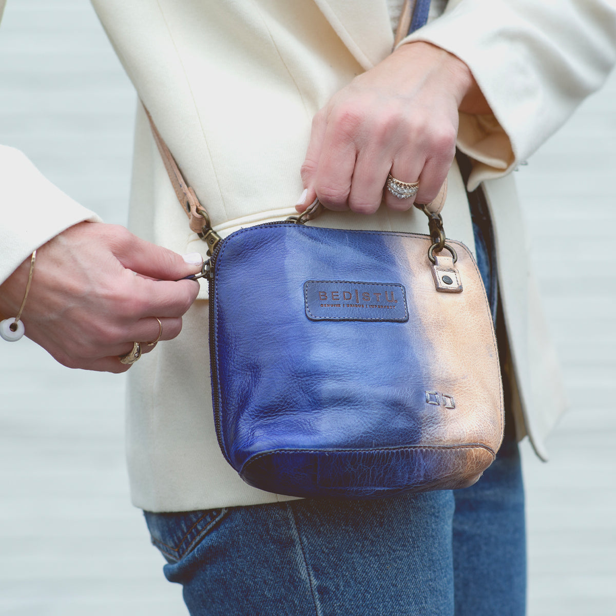 A woman holding a blue and white leather Ventura purse by Bed Stu.