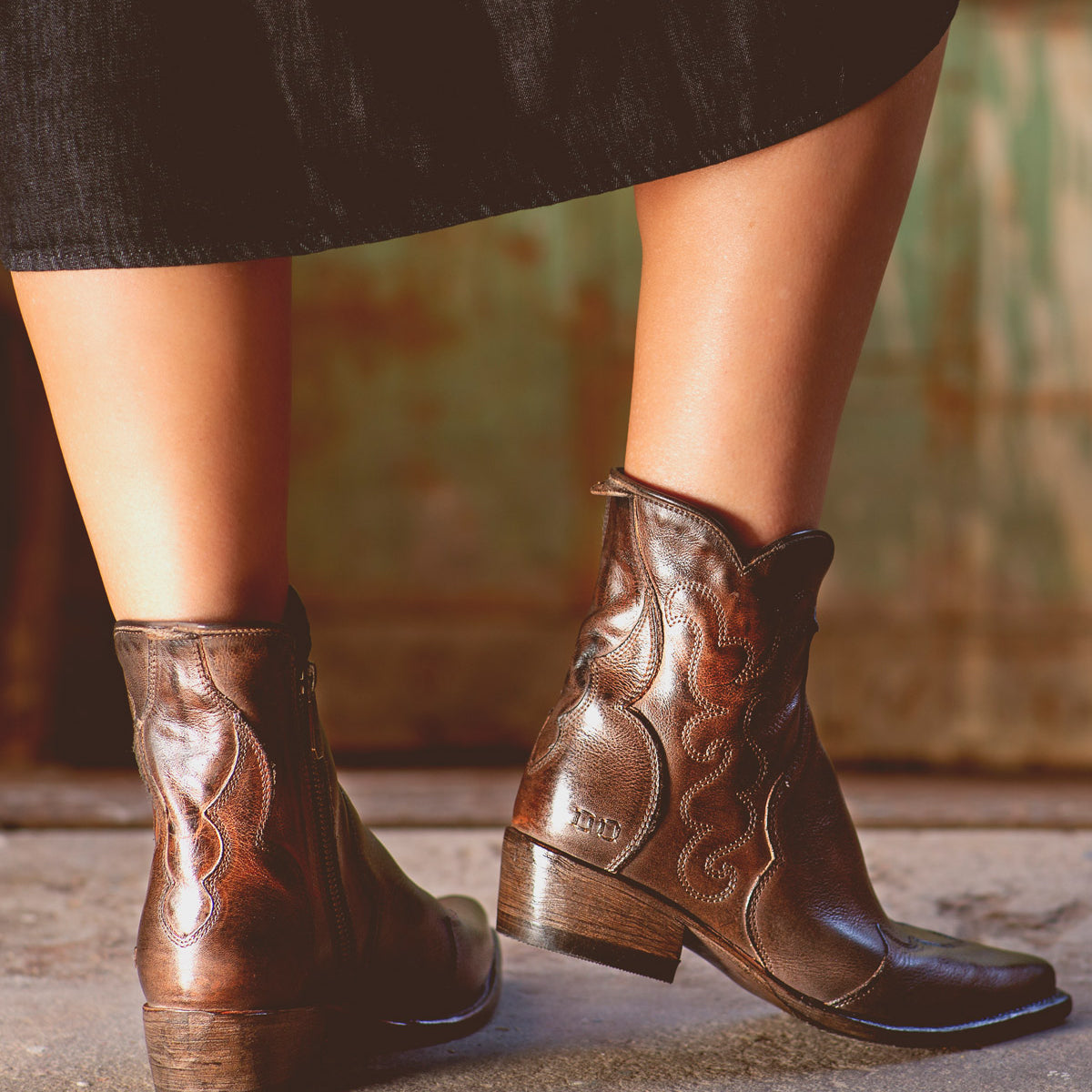 A woman sporting comfortable Ace leather cowboy boots with western style flair. (Brand Name: Bed Stu)