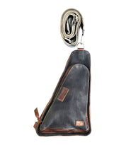 A versatile crossbody bag, the Bed Stu Adept, this black and brown leather sling is displayed vertically with the strap coiled neatly on top, making it an ideal travel companion.