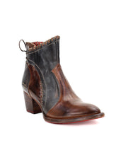 The Bia by Bed Stu is a comfortable leather bootie with a chunky heel, blending brown and black hues, featuring decorative stitching and a pull tab at the back.