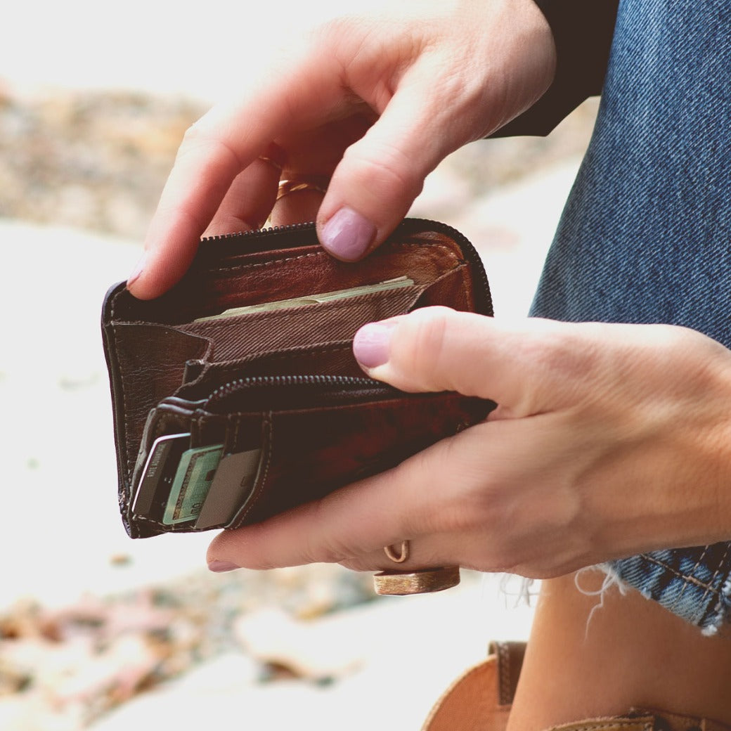 A woman holding a Bed Stu Carrie wallet in her hands.