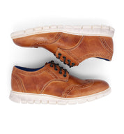 A pair of Bed Stu Cayuga II men's tan wingtip shoes on a white background.