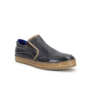 The Bed Stu Freestyle slip-on shoe in black leather, highlighted by brown stitching and a robust brown sole, also features a stylish blue inner lining that exudes casual sophistication.