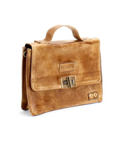 A brown leather briefcase with a handle on top, a clasp closure on the front, and the brand name "Bed Stu" embossed on the front flap. Combining fashion and functionality, this briefcase, named the Improv, also features an optional crossbody strap for added convenience.