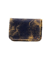 The Jeor wallet by Bed Stu boasts a compact size and a well-worn leather finish in a striking black and gold distressed texture, complete with convenient credit card slots.