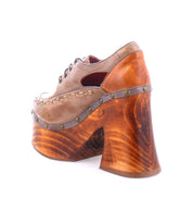 Side view of the Karaoke platform shoe by Bed Stu, featuring a single brown design with a chunky wooden sole and studs around the edge, evoking 70s era fashion.