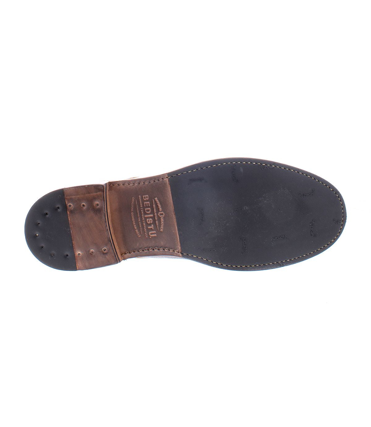 The image displays the sole of the Lincoln II leather shoe by Bed Stu, showcasing a stitched design and nail-like details on the heel, along with brand markings. The leather lining contributes to its polished appearance, enhancing both style and durability.