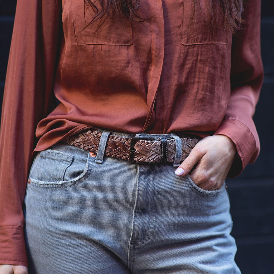 A woman wearing a braided leather belt with a metal buckle, the Proem by Bed Stu.