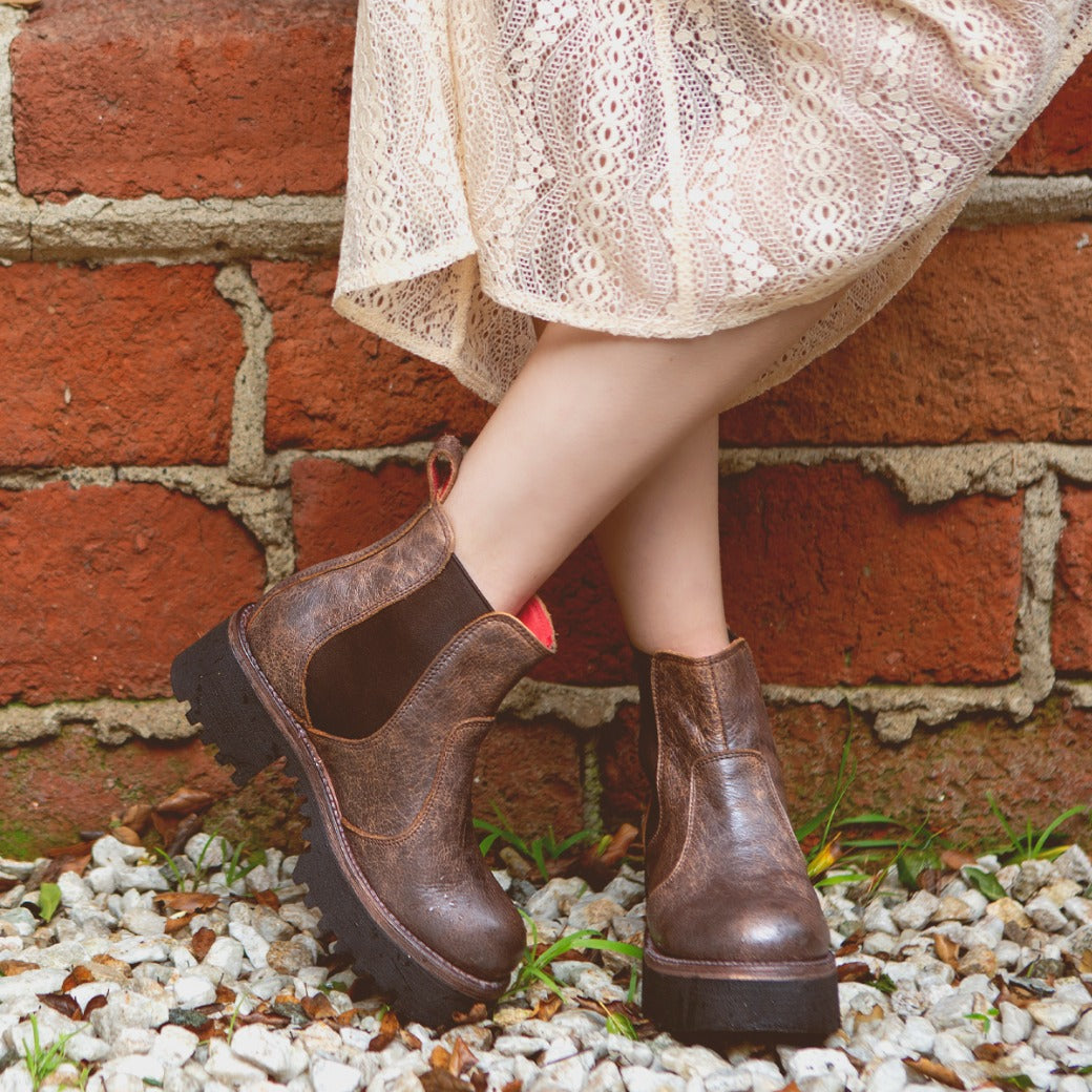 A woman wearing Bed Stu Valda Hi boots and a white dress.