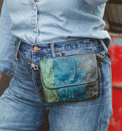A woman is holding a Ziggy fanny pack by Bed Stu.